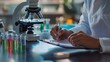 © Nazia - Scientist writing on clipboard in modern laboratory with test tubes and microscope