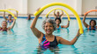 © Iryna - Senior African-American woman exercising with pool noodle in community wellness pool, fitness and group workout in aquatic therapy