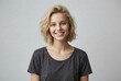 © Ohana - Portrait of a beautiful young caucasian woman with short blonde hair smiling happily while wearing a casual grey t shirt against a white studio background