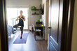 © AntonioDiaz - Full length view of a woman practicing yoga tree pose for wellness and balance in her modern bedroom apartment at home