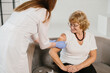 © dsheremeta - Nurse applying bandage after senior woman receiving vaccine