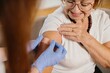 © dsheremeta - Senior woman receiving vaccination, nurse applying bandage on arm
