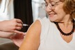 © dsheremeta - Senior woman receiving flu vaccination, smiling