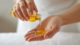 A person pouring oil from a bottle into their hand, showcasing a smooth, golden liquid, possibly for skincare or massage purposes.