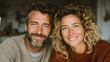 © Maryna - Man and woman are smiling for the camera. The man has a beard and gray hair, while the woman has curly hair and a smile