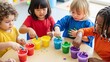 © Natalya - diverse group of preschool children finger painting with bright gouache on table for early childhood education blogs, daycare websites, creative kids development and art school posters