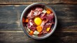 © mila103 - A stainless steel bowl filled with raw meat, an egg yolk, chopped carrots, and potatoes, placed on a rustic wooden table, ideal for pet nutrition concepts.