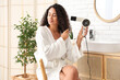 © Pixel-Shot - Beautiful young African-American woman using modern hair dryer in bathroom