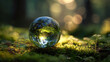 © AndyAziz - Glass sphere containing the earth resting on vibrant green moss with sunlight filtering through trees in the background