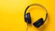 © sakmad - Overhead black and yellow headphones on bright yellow background, angled view