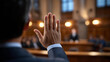 © Curioso.Photography - A man raises his hand inside a formal courtroom during a legal proceeding.