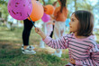 © nicoletaionescu - Little Girl Painting on Balloons During Outdoor Activity in the Park. Happy kid expressing creativity in an art contest outdoors
