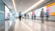 © CStock - A bustling modern hallway with blurred figures walking past vibrant advertisements and bright lighting.