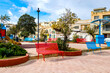© EKH-Pictures - Birzebbuga, Malta – colorful public square with modern seating, playground equipment, paved paths and old house facades, typical of Maltese coastal towns