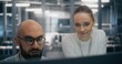 © Framestock - Team Consulting Over Console in Control Room. Digital infrastructure experts consulting over workstation console, deeply engaged in technical discussion. Concept of enterprise level system management.