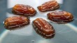 © Mila - A close-up of dates soaking in water with small bubbles on their surface, representing the preparation for Iftar during Ramadan.