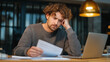 © retrostudio - A person filing an insurance claim on a laptop, with a concerned expression