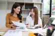 © SOMKID - Two asian businesswoman using digital tablet and talking about business with analyzing financial charts in the modern office.