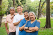 © Prot - Four older adults enjoy a cheerful moment together in a lush outdoor setting. Their smiles and relaxed poses highlight themes of friendship, active aging, and joy of social connection in later life.