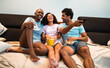 © Nexa - Diverse group of happy friends laughing while watching a movie and eating popcorn at home.