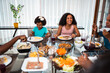 © Nexa - Happy multi-generational Black family enjoying a healthy lunch together at home.
