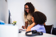 © Nexa - African American mother helping her young daughter with homework or online learning at a desk in a home office.