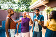 © Nexa - Happy multi-ethnic group of friends and family toasting with beer glasses by a swimming pool at a backyard party.