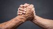 © Dmytriy - Close-up of two male hands clasped in a firm grip symbolizing struggle or greeting