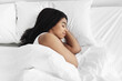 © Prostock-studio - Healthy sleeping. Young african american woman sleeping in her bed at home, copy space, top view. Black lady having nap, resting in white cozy bedroom