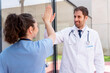 © StockMe - Medical professionals celebrating teamwork and success with a high five, expressing collaboration and partnership in modern healthcare environment, achieving goals together