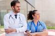 © StockMe - Doctor and nurse stand together outside a hospital with arms crossed, projecting confidence, teamwork and dedication to patient care and community health in a modern clinical setting