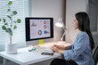 © Wasana - Asian businesswoman analyzing financial charts on computer in modern office