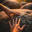 © Sukaesteler - Hands Touching Rock at Sunset Time.