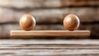 © svastix - Two wooden balls perfectly balanced on a minimalist wooden bar symbolize harmony and equilibrium in design, reflecting principles of stability and simplicity in decor.