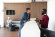 © Jelena - Business Meeting At Modern Reception Desk: Two Men Discussing Details In Bright Lobby