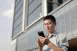 © zhu difeng - asian businessman using smart phone outdoor