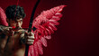© apimagine - A handsome Cupid god with heart-shaped tattoos on his body, holding wings of love against a red background