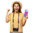 © Damir Khabirov - Excited young woman celebrating with fist pump holding passport and tickets with camera around neck