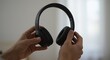 © Photyn Studio - Hands hold a pair of wireless headphones, highlighting a modern device for personal audio entertainmentConcept of portable audio technology and entertainment