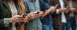 © miss irine - Group of people looking at phones. Friends gather using cell phones, sharing online content. Adults hold mobile devices, connected digitally, ignoring each other.