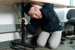 © fotolite - An Asian student crouches under a desk with hand protecting his head during an earthquake safety drill, ideal for school safety, emergency preparedness, or disaster drill concepts.