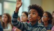 © Vadym - Young black boy raises hand in classroom. Students listen to teacher lecture. Kids learning together, eager to ask questions and gain knowledge at school.