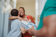© Nexa - Happy African American grandmother hugging her grandson at the front door while receiving a gift from family.