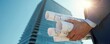 © Pete - Man holds rolled architectural plans near modern skyscraper under bright sun. Pro reviews building design before construction. Ready for urban development project.