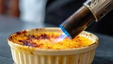 Caramelizing Sugar Topping On A Creamy Dessert With A Culinary Torch In A Kitchen Close Up Shot