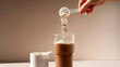 © Retno - A person adding protein powder to a glass of smoothie for a healthy and active lifestyle.