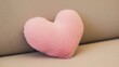 © Nataly - Pink fluffy heart shaped pillow on a beige sofa. Soft plush cushion for home decoration. Valentine's Day love concept