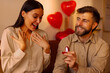 © Home-stock - Happy man holding and giving open box with engagement ring to his surprised girlfriend, asking to marry him during romantic date