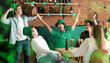 © Pixel-Shot - Group of young people with beer celebrating St. Patrick's Day in bar