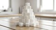 © Saidatul - Sugar Cubes Stacked Pyramid on Wooden Table.